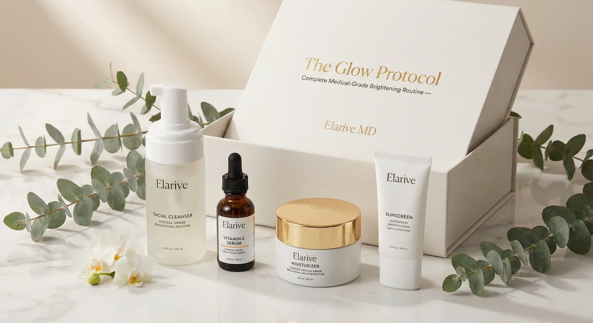Elarive MD The Glow Protocol kit featuring a facial cleanser, vitamin C serum, collagen moisturizer, and sunscreen, presented in a decorative box with eucalyptus leaves and flowers.